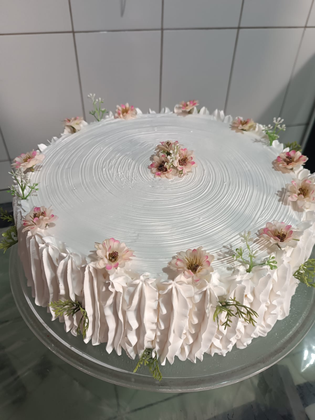 Bolo branco redondo decorado com flores