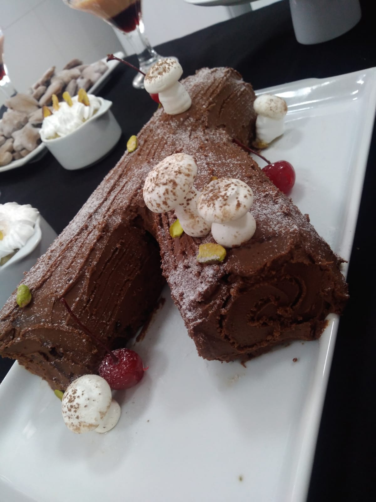 Rocambole de chocolate decorado com creme e cerejas